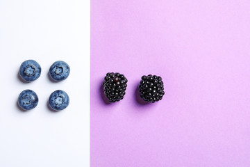 Flat lay composition with blackberries and blueberries on color background