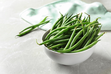 Bowl with fresh green French beans on table