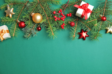 Flat lay Christmas composition with festive decor and gift boxes on color background