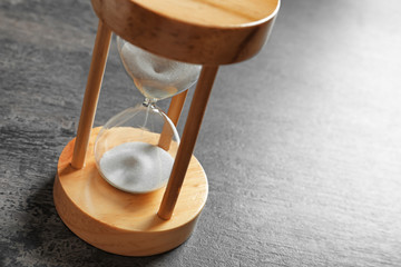 Hourglass with flowing sand on table. Time management