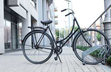 Fototapeta na wymiar Modern black bicycle parked on city street