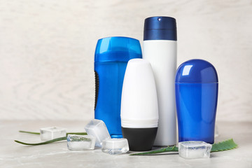 Different deodorants, ice cubes and aloe on table. Personal hygiene