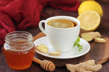 Cup of ginger tea with honey and lemon on wooden table