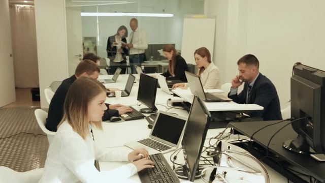 Successful coworkers engaged in business activities in busy open plan office