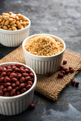 Crushed peanuts or mungfali powder with whole and roasted groundnut. Served in a bowl over moody background. Selective focus