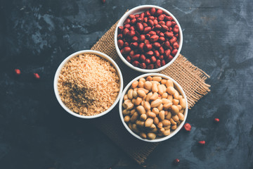 Crushed peanuts or mungfali powder with whole and roasted groundnut. Served in a bowl over moody background. Selective focus