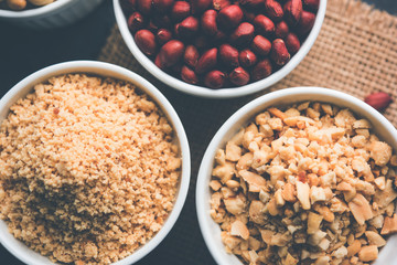 Crushed peanuts or mungfali powder with whole and roasted groundnut. Served in a bowl over moody background. Selective focus