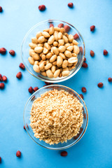 Crushed peanuts or mungfali powder with whole and roasted groundnut. Served in a bowl over moody background. Selective focus