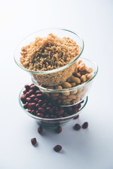 Crushed peanuts or mungfali powder with whole and roasted groundnut. Served in a bowl over moody background. Selective focus