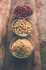 Crushed peanuts or mungfali powder with whole and roasted groundnut. Served in a bowl over moody background. Selective focus