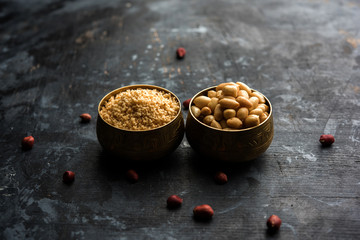 Crushed peanuts or mungfali powder with whole and roasted groundnut. Served in a bowl over moody background. Selective focus