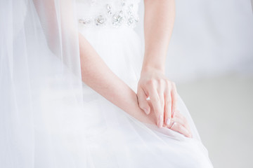 Bride holds her hands crossed on the knees