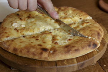 Hot pizza with cheese on a white plate in a restaurant, Italian traditional appetizer.
