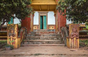Fototapeta na wymiar facade and entrance with stairs to a abandoned and decadent buddhist temple in cambodia