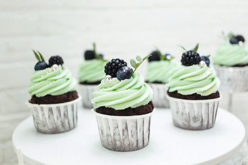  Delicious sweet cup-сakes for the holiday. Cakes with creamy green cream and fresh berries