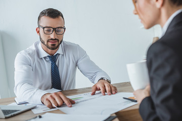 male and female financiers working with documents in office