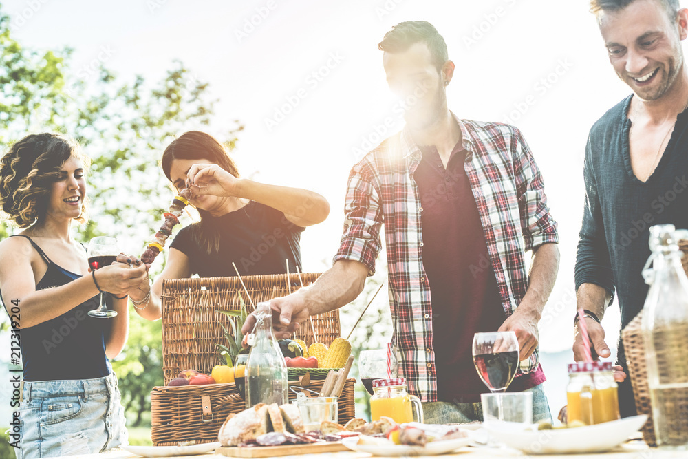 Wall mural Happy millennials friends preparing barbecue dinner outdoor in nature