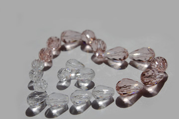 Glass beads collected in a heart shape on a white background isolated.