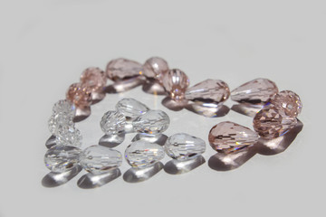 Glass beads collected in a heart shape on a white background isolated.