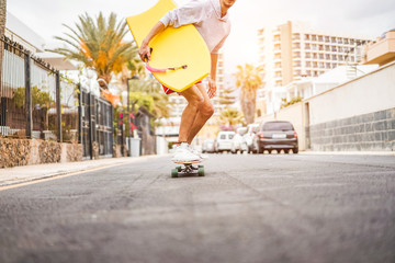 Young man riding longboard around city streets