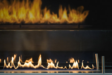 Fire burs on the stove and reflects in the glasses