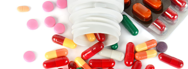 Assorted pharmaceutical medicine pills, tablets and capsules isolated on white background. Wide...