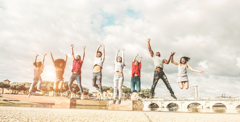 Happy millennials friends jumping outdoor - Young people having fun together