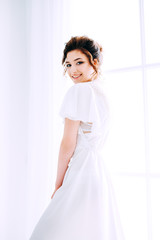 Tender elegant young bride with hairdo, hairpin and bridal makeup