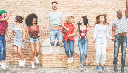 Happy millennials friends jumping outdoor