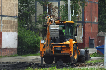 tractor, with bucket, breaking asphalt