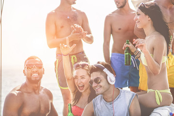 Happy friends dancing and drinking beers at boat dj set party