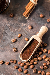 Roasted coffee beans and grains ground into a wooden spoon