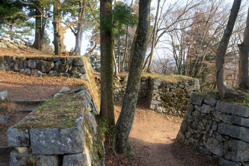 Early morning sunlight streams through entrance between stone castle walls