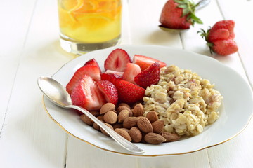 Oatmeal porridge, fresh strawberries, almonds for breakfast