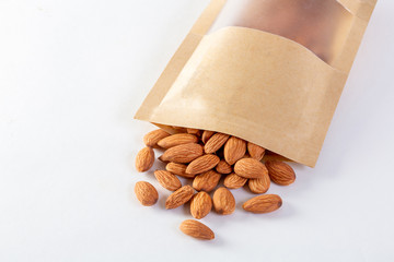 Almonds packed in paper bags on a white background.