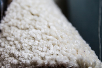 A piece of beige carpet without overlock