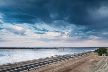  city ​​landscape with a dramatic sky, a view of the river with a bridge, a pre-threat sky