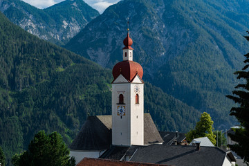 Fototapeta na wymiar 30 june 2018: View of the little village of Assling (Tyrol region, Austria) with the Tyrolean alps in the background