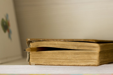 thick books on a wooden shelf