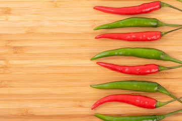 Close up red and green chilli pepper on wood chopping board..