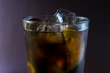 Glass  with cola lemon and ice like whiskey cola or long island cocktail