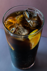 Glass  with cola lemon and ice like whiskey cola or long island cocktail