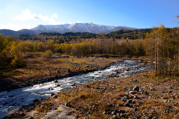 winter view of snow mountain and stream in hokkaido daisetsuzan national park