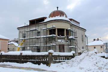 Reconstruction of old suburban house with new exterior surrounded with building scaffolding and...
