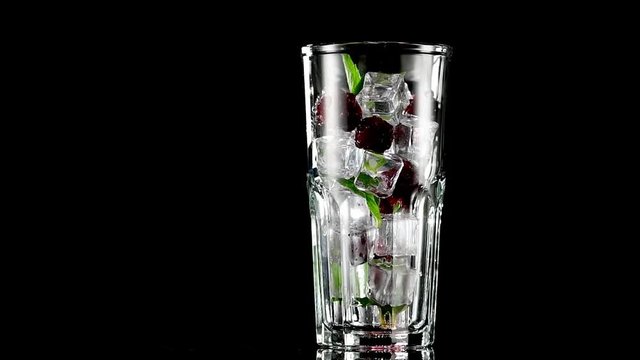 cold drink with blackberries and mint on a black background