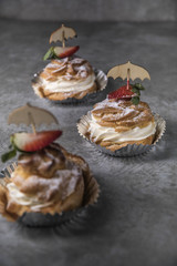 Homemade profiteroles with cream, strawberries and mint. Dessert for gourmets.