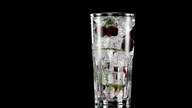 cold drink with blackberries and mint on a black background