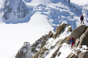 Bergsportler am Gipfel des Dôme du Goûter und strahlend blauer Himmel des Mont-Blanc-Massivs,...