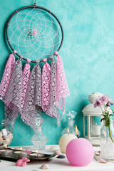 Dream catcher on aquamarine wall background