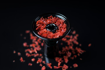 Hookah bowl with red tobacco on black background